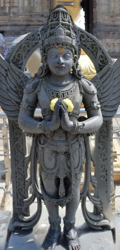 Intricate grey stone statue in outdoor setting.