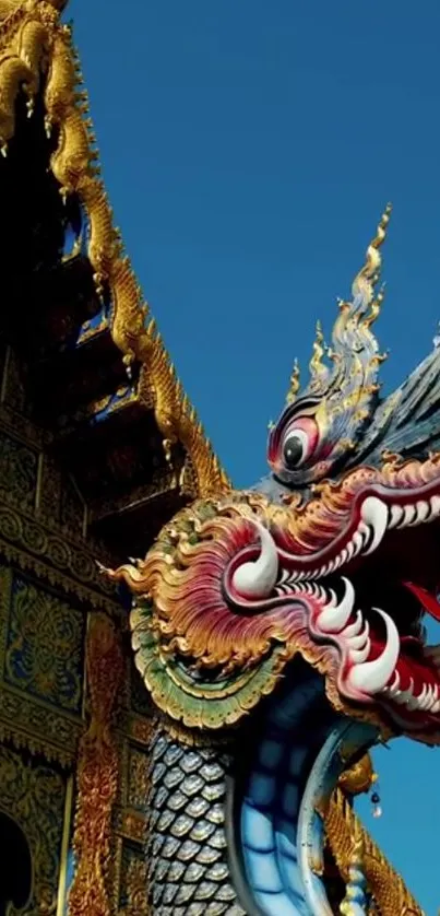 Intricate dragon sculpture on Thai temple roof against blue sky.