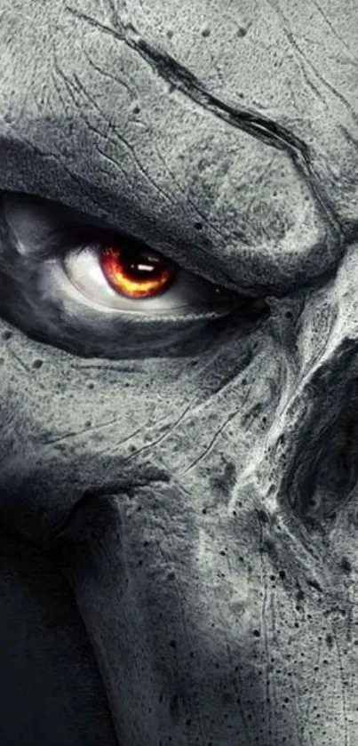 Close-up of a stone skull with a fiery eye set against a textured background.