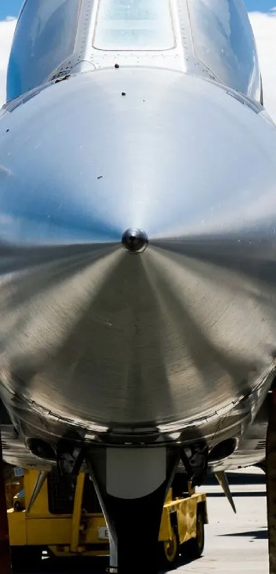 Sleek silver jet fighter's front view with clear blue skies.