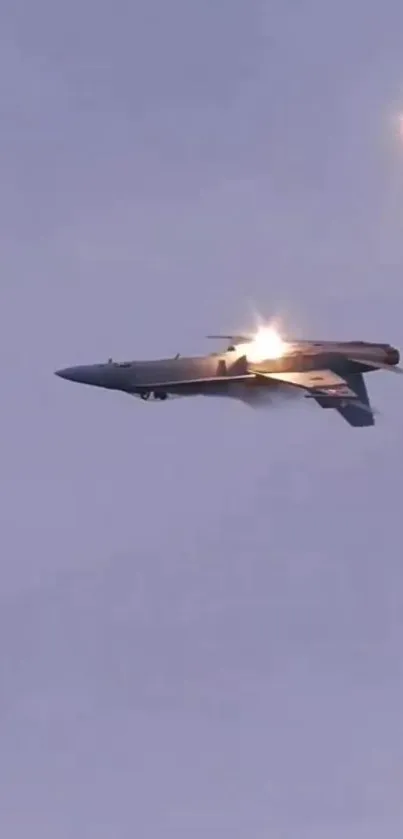 Jet fighter flying in the twilight sky with bright flares and blue backdrop.