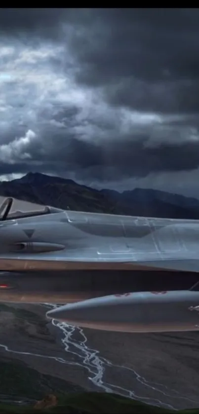 A jet fighter flying over mountains under a dramatic cloudy sky.