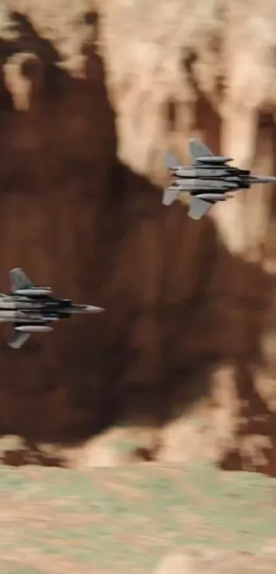 Two jet fighters flying through a desert canyon landscape.