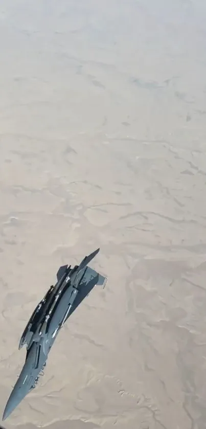 Jet flying over a beige desert landscape, capturing aerial aviation beauty.