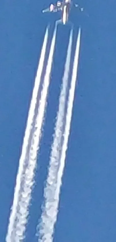 Jet soaring with contrails in blue sky.