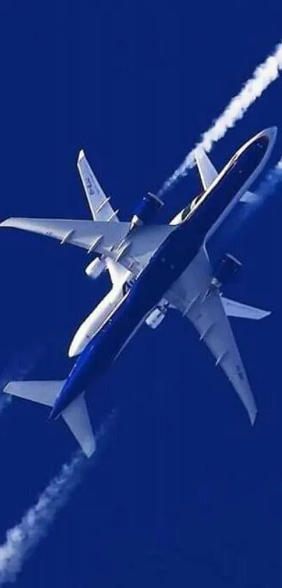 Jet plane soaring in blue sky with contrails.