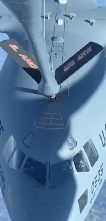 Aerial view of jet refueling mid-air.