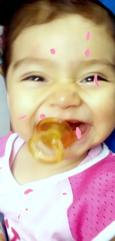 Joyful baby with pacifier and pink petals in mobile wallpaper.