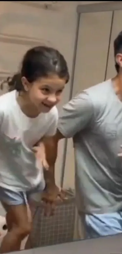 Father and daughter having fun in the bathroom mirror.