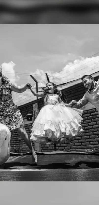 Black and white wallpaper of a joyful family jumping.