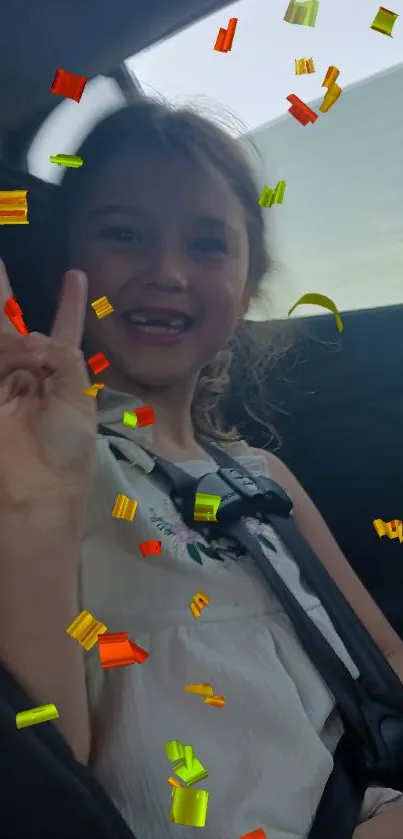 Child smiling in a car, surrounded by colorful falling confetti.