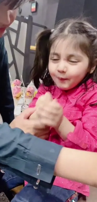 A cheerful child enjoying a playful moment in vibrant pink attire.