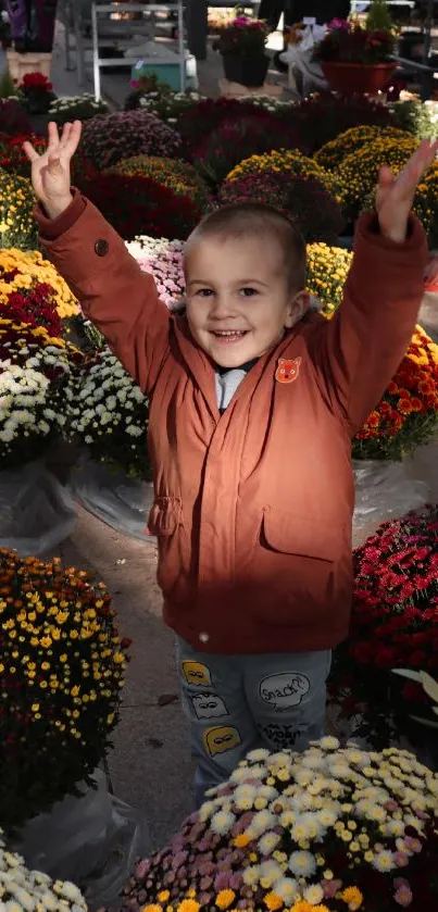 Smiling child in brown jacket among colorful flowers.