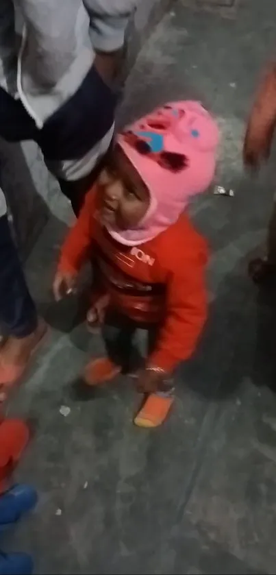 Toddler in colorful outfit with a joyful expression.