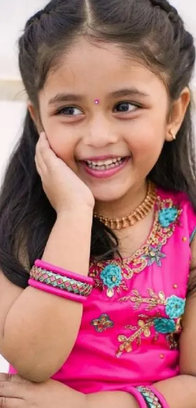 Joyful girl in pink dress with happy expression.