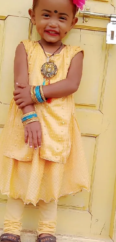 Smiling child in yellow attire with colorful accessories.