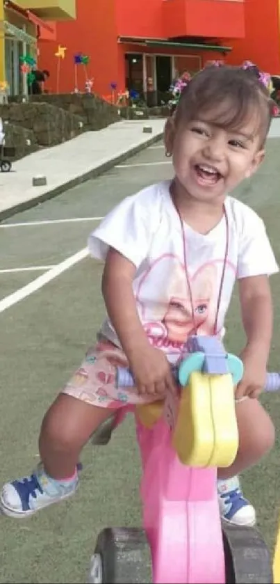 Joyful child riding a toy bike with vibrant colors and a smile.