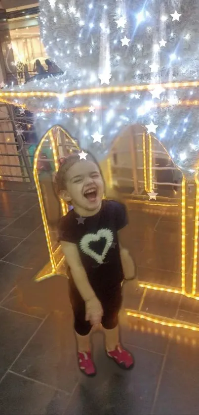 Joyful child surrounded by twinkling lights with a heart shirt.