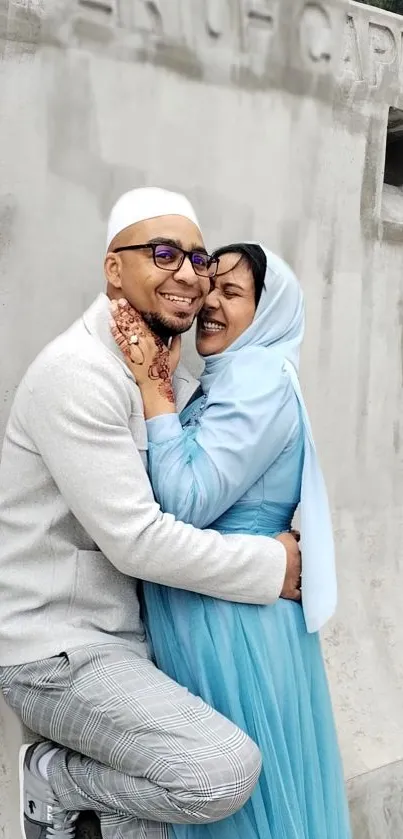 Joyful couple in light blue attire sharing a happy moment.