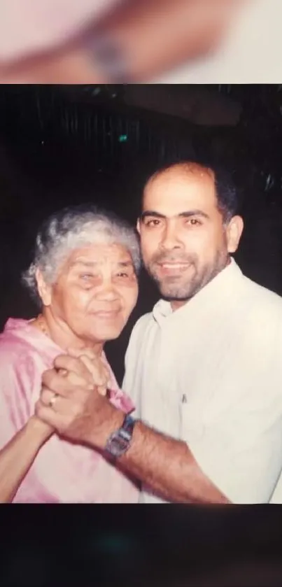 An elderly woman and a man dancing happily together.