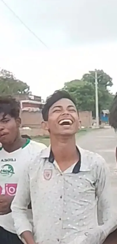 Group of friends laughing outdoors on a cloudy day.