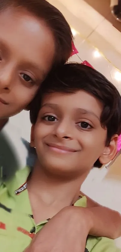 Two joyful kids smiling with festive background.