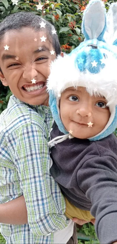 Two kids posing happily, one in a blue bunny hat.