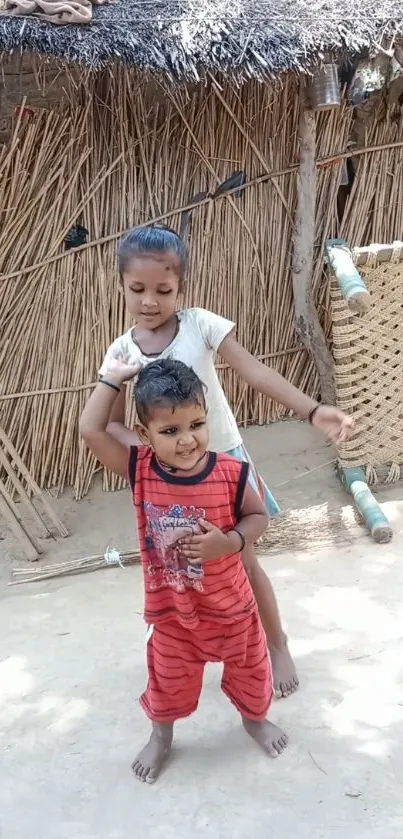 Two smiling kids playing in a rustic setting.