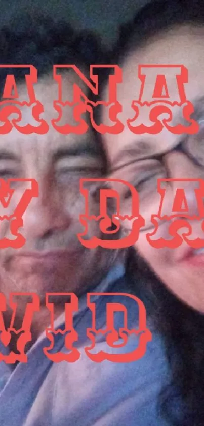 A smiling couple with red text overlay on a mobile wallpaper.