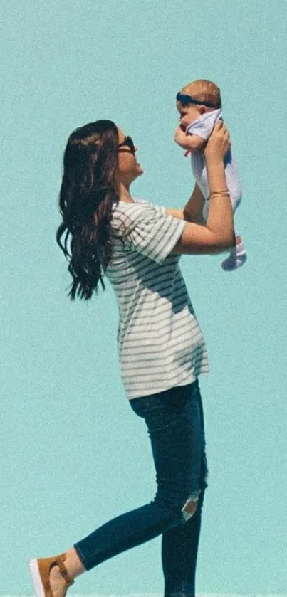 Mother joyfully holding baby against light blue background.