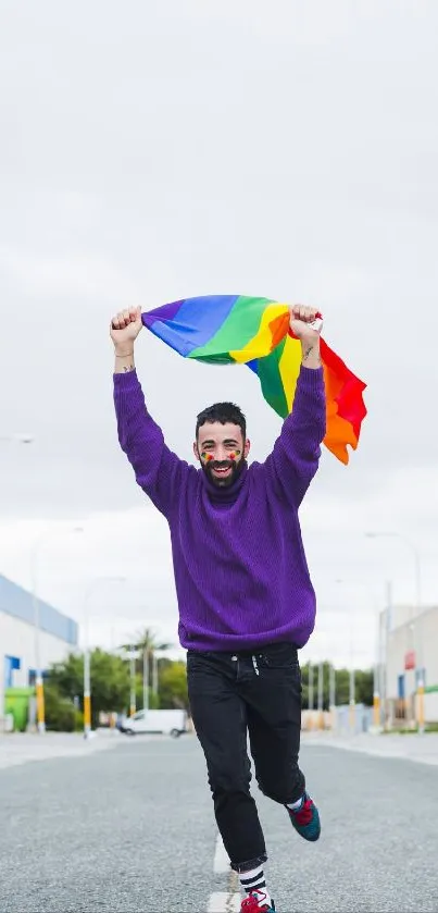 Person joyfully running with rainbow flag on a city street.