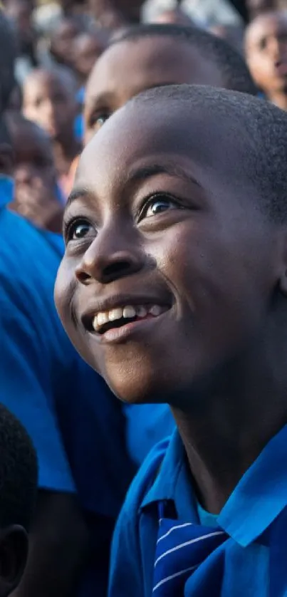 Children in blue uniforms smiling at a school event.