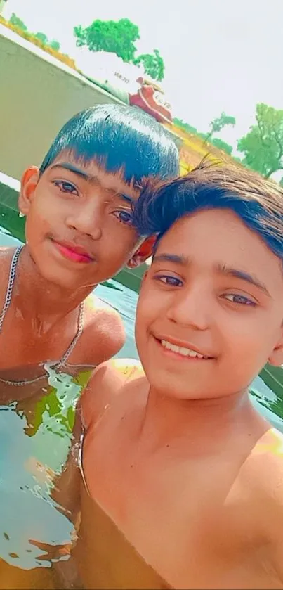 Two smiling friends enjoying a dip in a green pool with nature in the background.