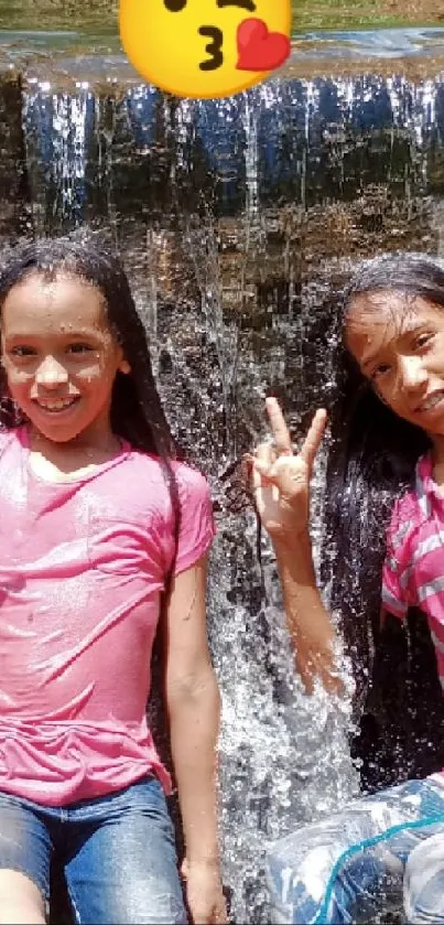 Two kids playing by a waterfall, smiling and enjoying the outdoors.