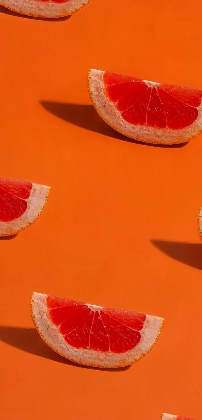 Grapefruit slices on a bright orange background, creating a vibrant phone wallpaper.