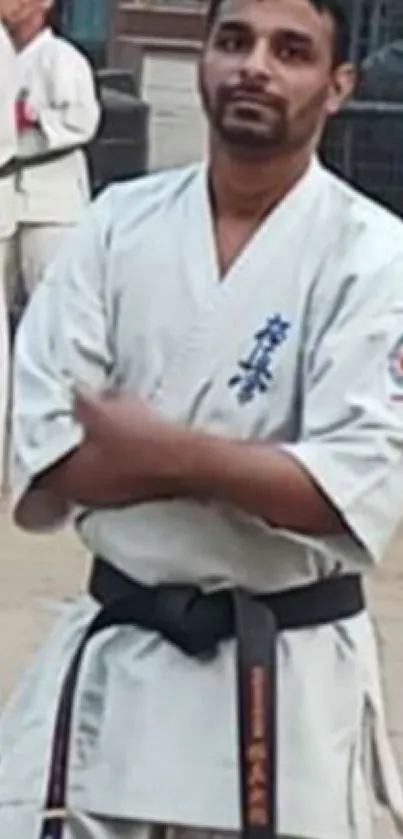 Karate practitioner posing outdoors in traditional white gi.