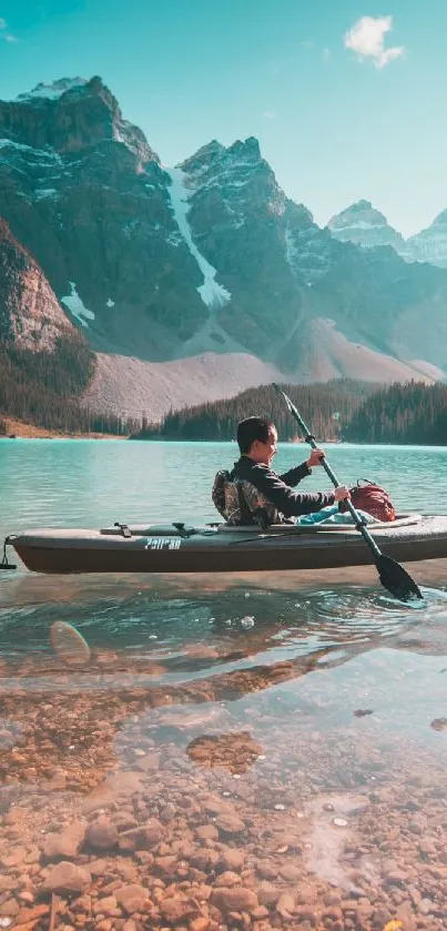 Person kayaking on turquoise lake with mountains in background.