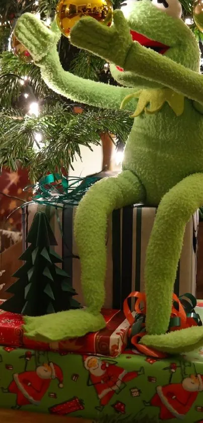 Kermit decorates a Christmas tree with gifts below.