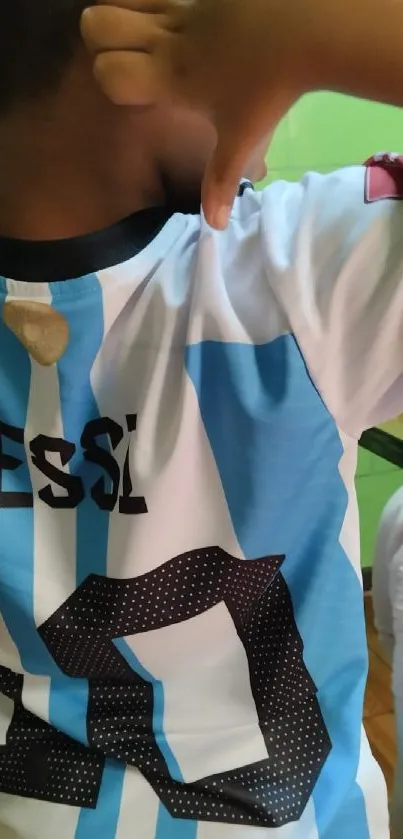 Child in striped soccer jersey showing excitement.