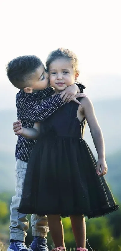 Children hugging on a scenic hillside with a serene background.