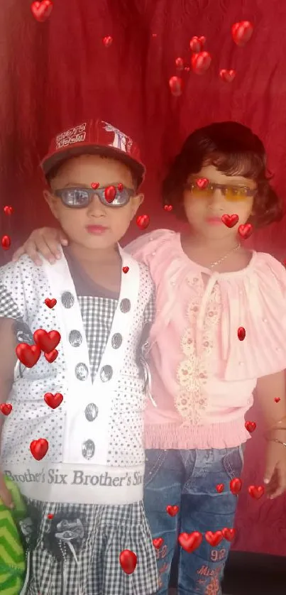 Two children in stylish outfits against a vibrant red background.