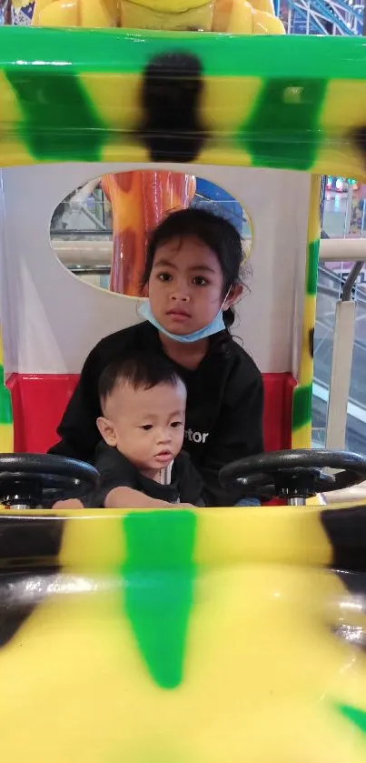 Two kids enjoying a colorful ride.