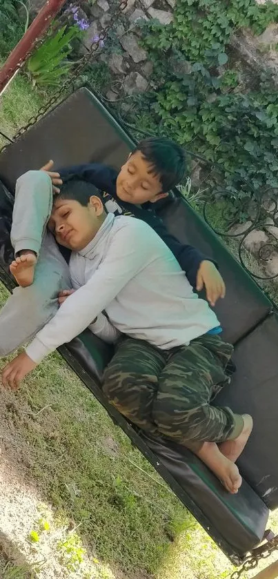 Two kids resting on a garden swing in nature.