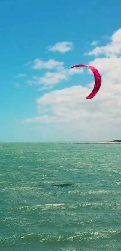 Kite surfing over turquoise ocean under a clear blue sky.