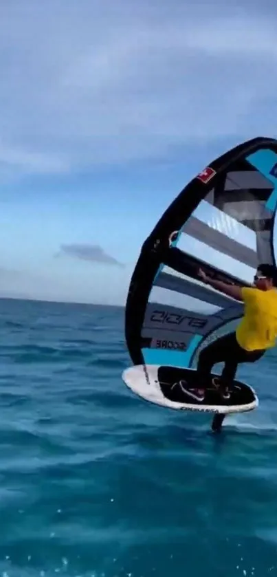 Kitesurfer gliding over blue ocean waves on a sunny day.