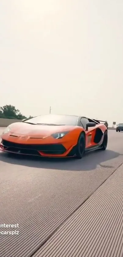 Orange Lamborghini speeding on a highway, showcasing its sleek design.