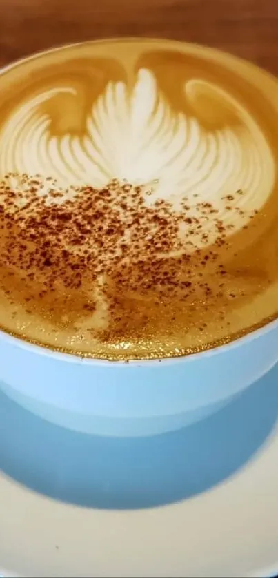 A cappuccino with latte art on a wooden table.