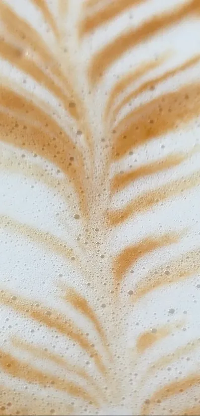 Close-up of latte art with coffee foam swirls in light brown and creamy textures.