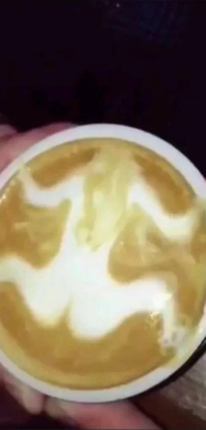 Latte art with intricate swirl design in a coffee cup.