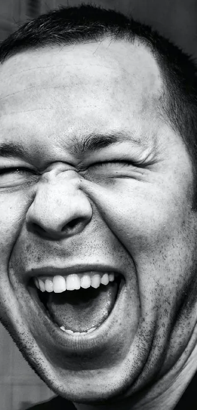 Black and white image of a man laughing energetically.
